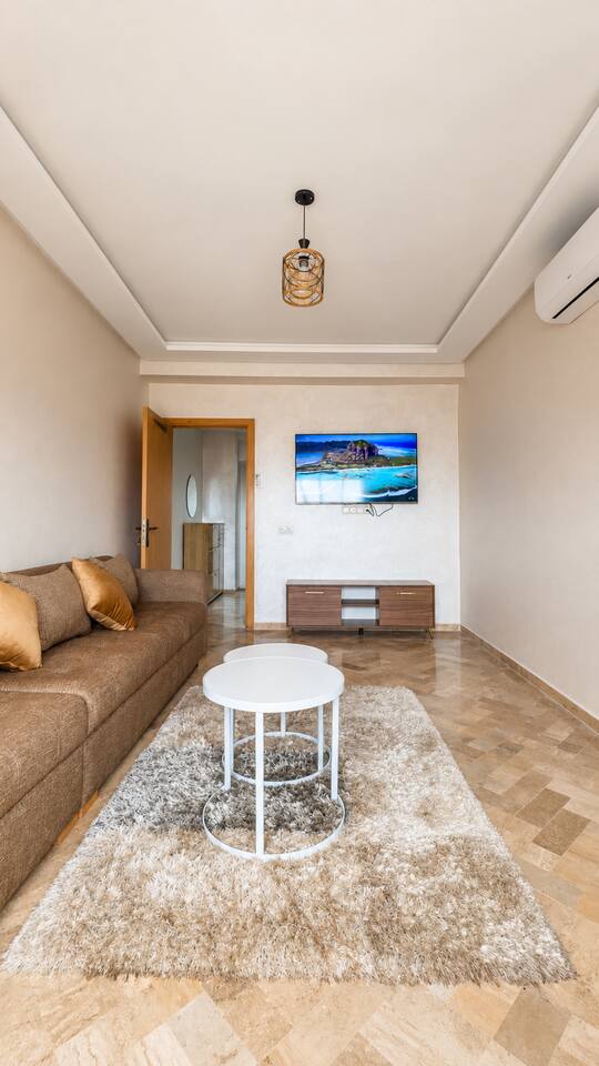 Front view of the living room with smart TV and large sofa near Agadir Bay.