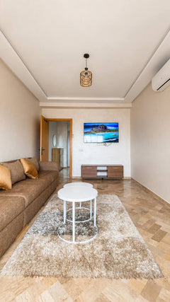 Front view of the living room with smart TV and large sofa near Agadir Bay.