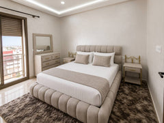 Main bedroom with upholstered double bed and balcony access in the premium apartment near Agadir Bay.
