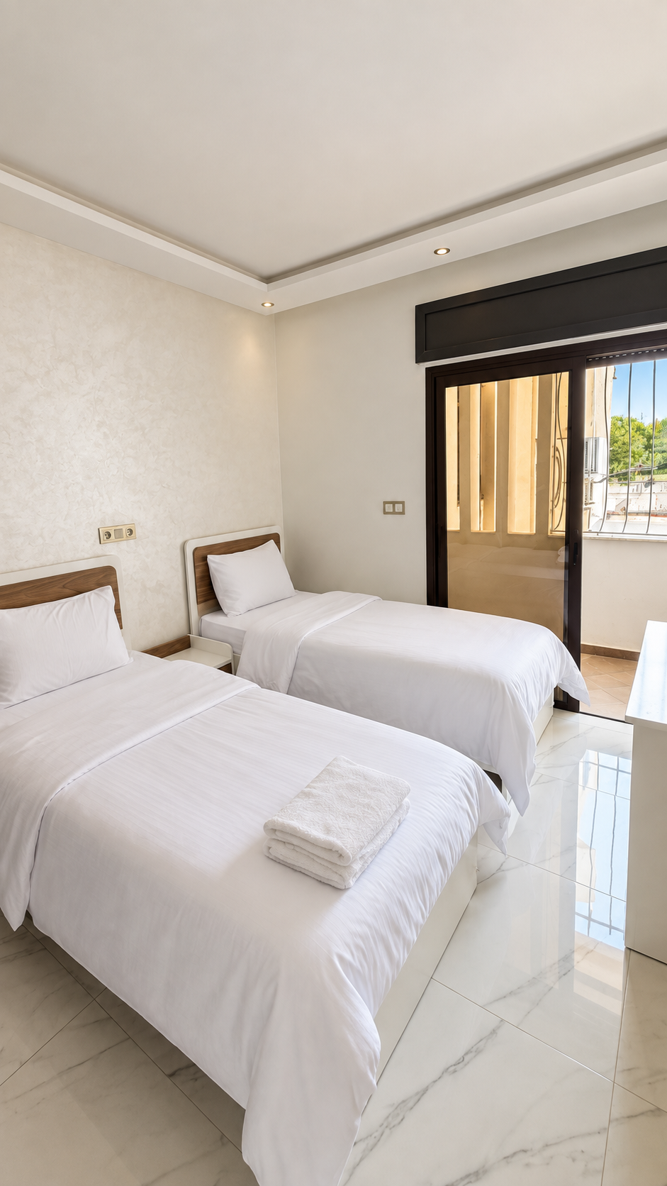 Twin beds beside window at the Central Agadir holiday apartment near the beach and souk