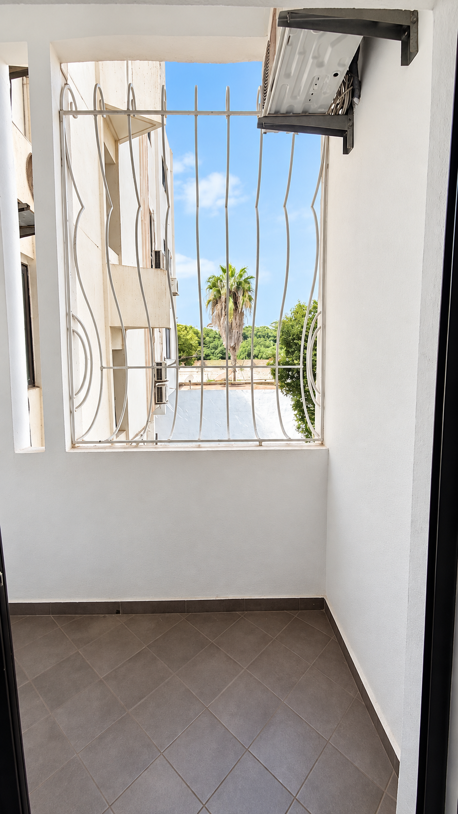 Balcony with glass door at the Central Agadir holiday apartment near the beach and souk