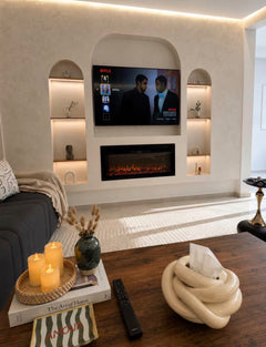 Feature wall lounge in DHAJIA Tilila, Agadir apartment with TV, warm lighting and refined interior styling.