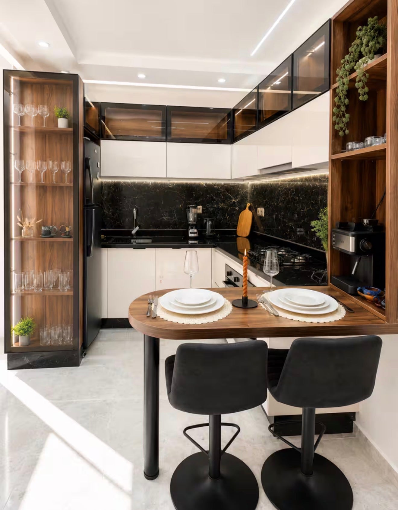 Kitchen and dining area in DHAJIA Tilila, Agadir apartment with modern black worktops and seating.