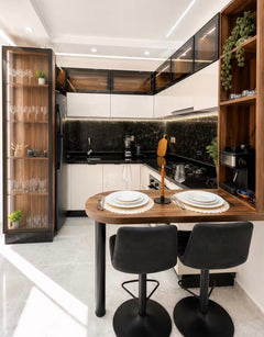 Kitchen and dining area in DHAJIA Tilila, Agadir apartment with modern black worktops and seating.