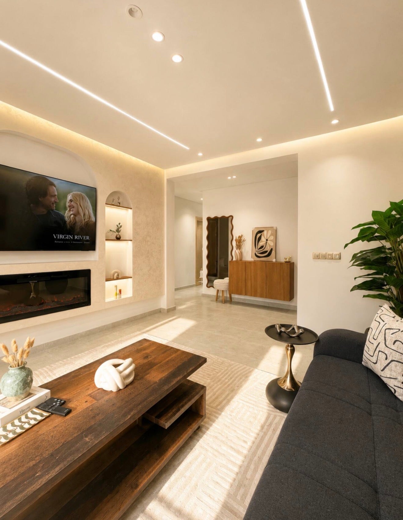 Lounge and TV wall in DHAJIA Tilila, Agadir apartment with modern seating and warm feature lighting.