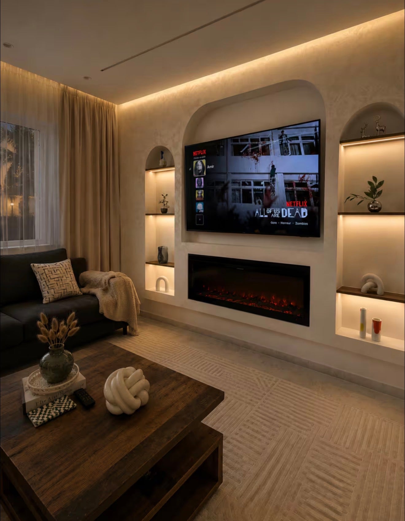 Modern TV feature wall in DHAJIA Tilila, Agadir designer apartment with warm lighting and built-in shelving.