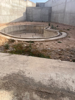 Unfinished concrete swimming pool shell in the villa courtyard