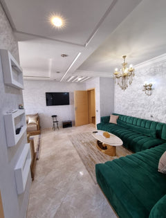 Green sofa and television area — Résidence Elkatani, Les Jardins d’Agadir, 79 m²