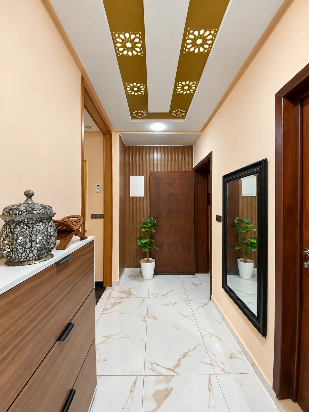 Apartment foyer with gold ceiling details and wood cabinetry in the presidential apartment, Agadir