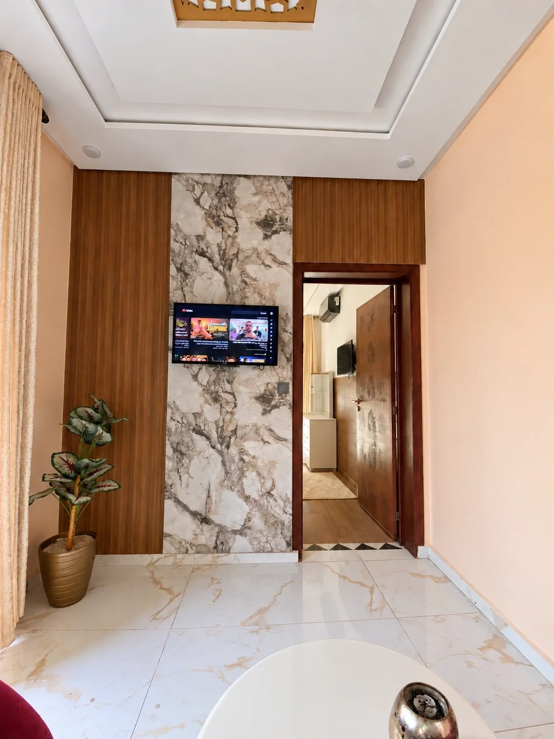 Wood and marble-look feature wall in an apartment sitting space in the presidential apartment, Agadir
