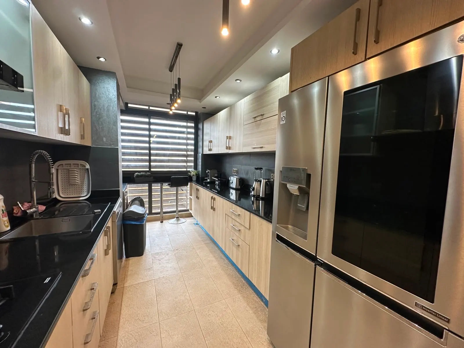 Fully equipped galley kitchen with large fridge-freezer at the Iken Gardens apartment.