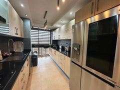 Fully equipped galley kitchen with large fridge-freezer at the Iken Gardens apartment.
